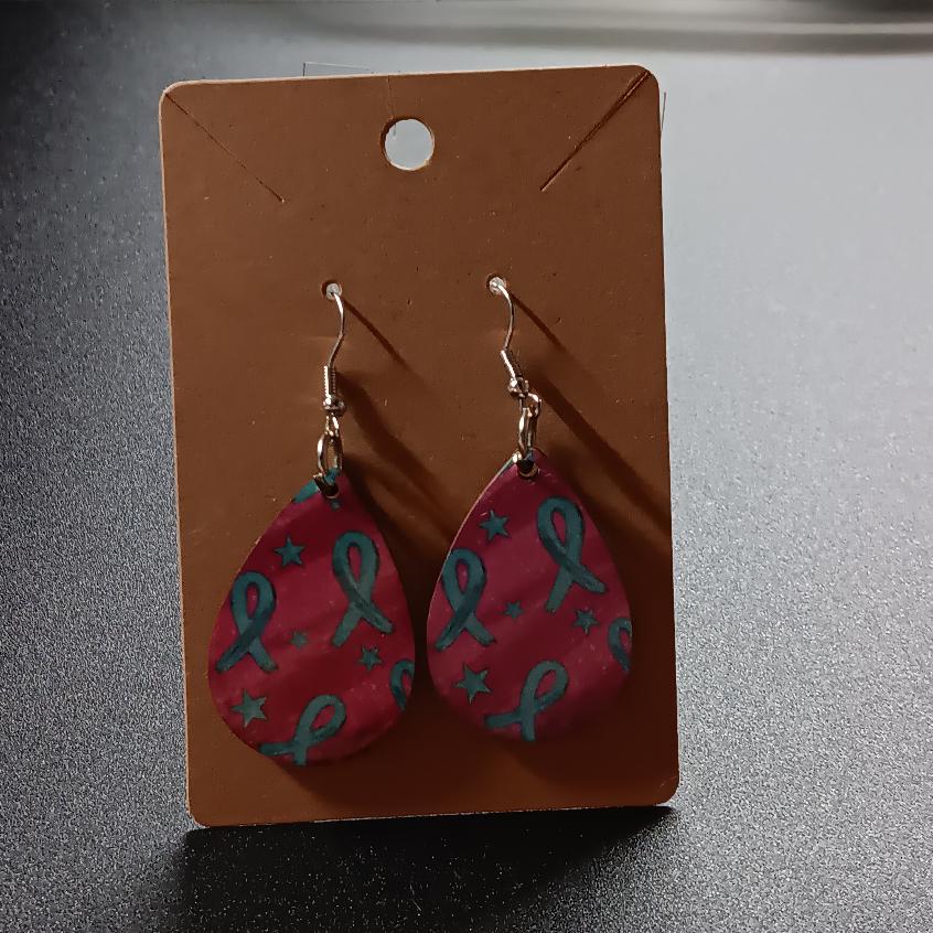 Bright pink teardrop earrings with teal ribbons and stars, one pair
