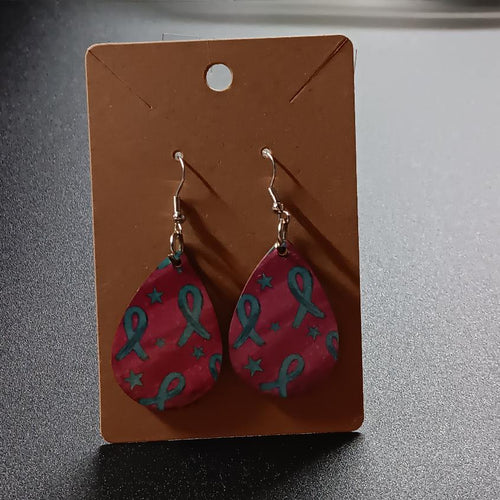 Bright pink teardrop earrings with teal ribbons and stars, one pair