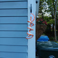 Small white crochet spiral wind spinner with orange edging and an orange center.