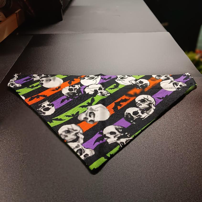 Medium Halloween pet bandana in a skull and bats print with orange, purple, and green stripes